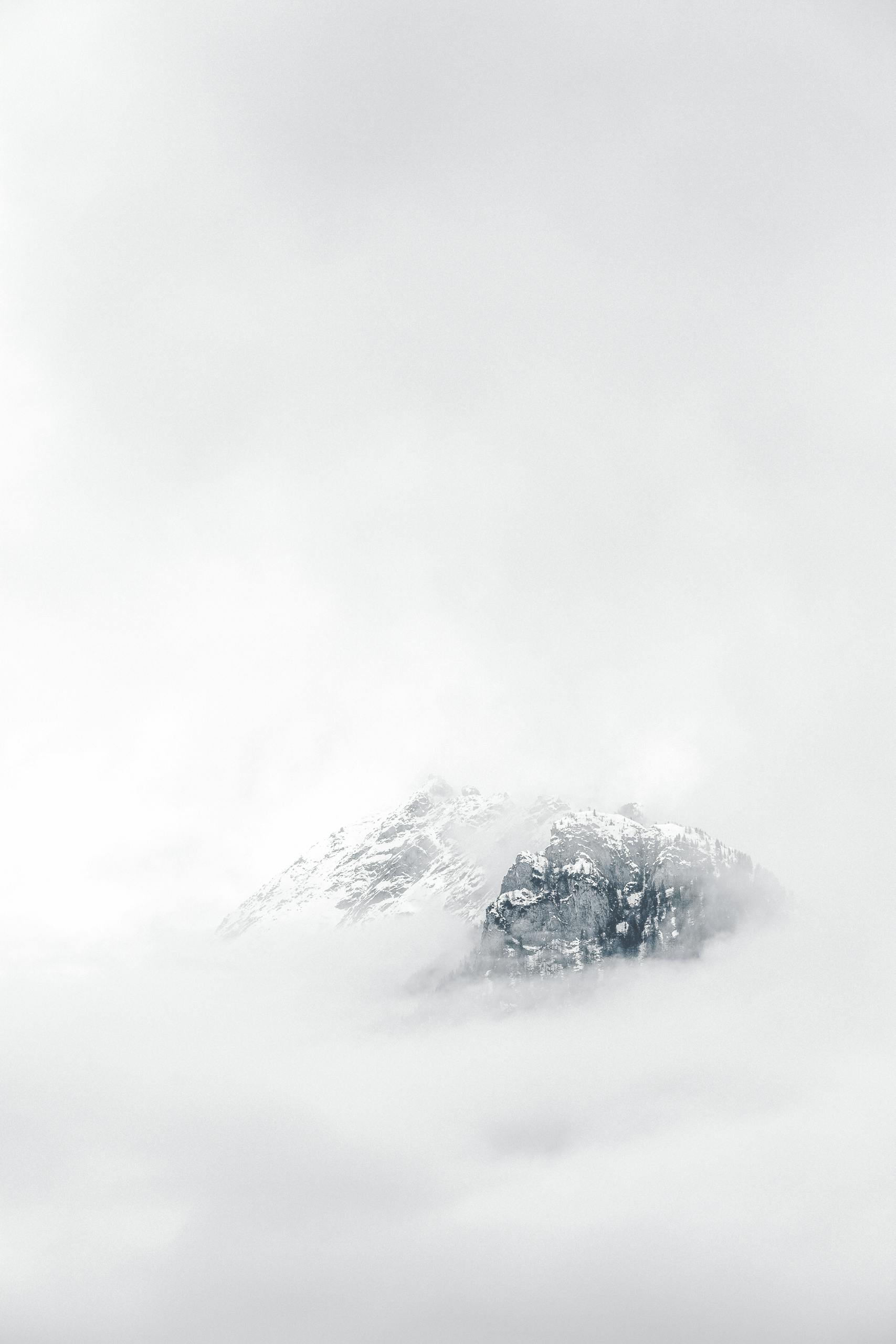 A minimal snowy mountain peak emerging from soft fog, symbolizing clarity, calm, and steady growth. Evokes the emotional tone of staying grounded in your content journey—even through uncertainty.