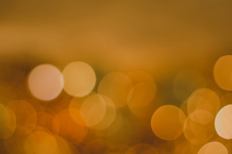 Soft-focus golden bokeh lights representing calm, clarity, and reflective momentum in online business growth.