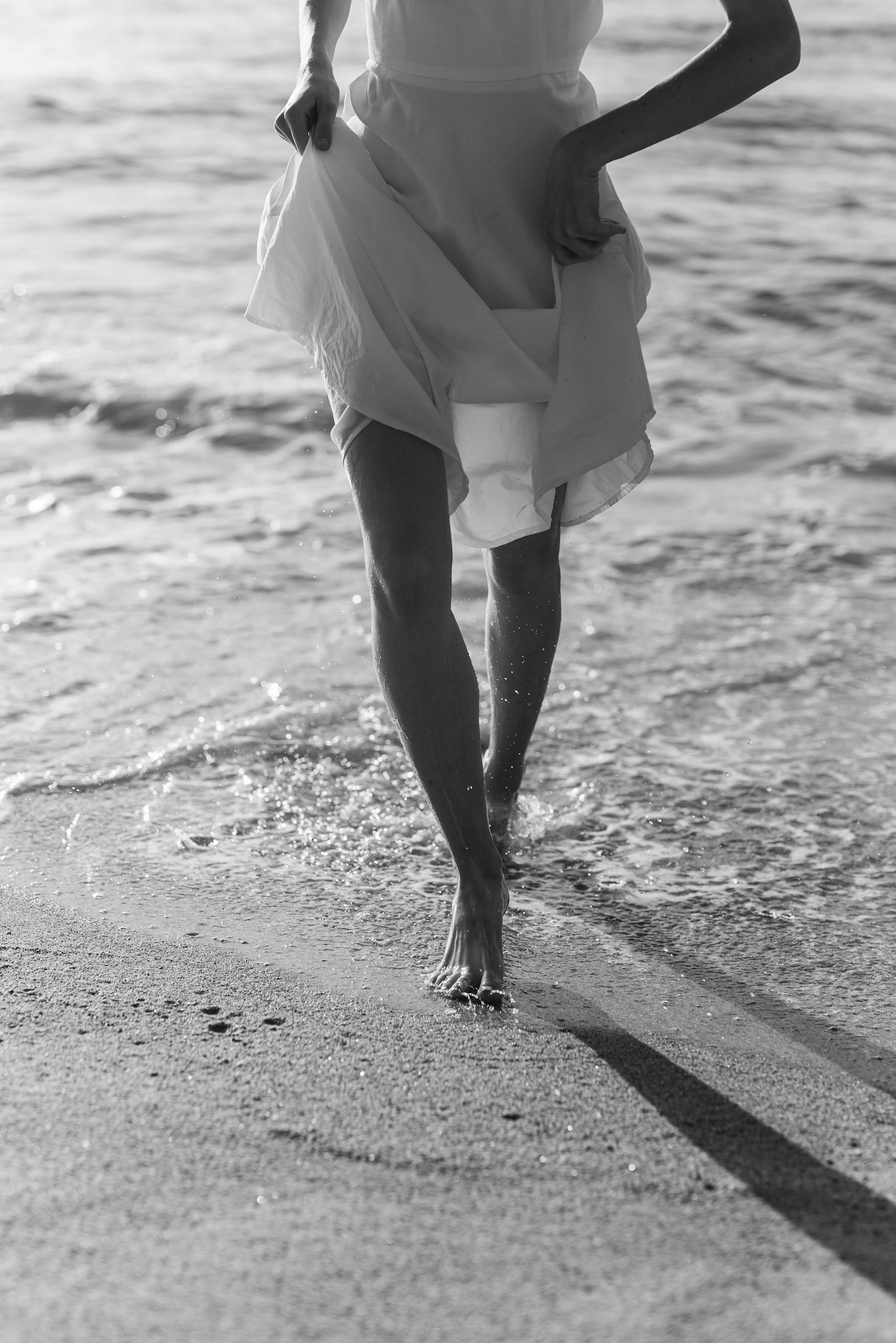 A woman walking alone on the beach, captured in soft black-and-white tones — symbolizing clarity, solitude, and a fresh new direction.
