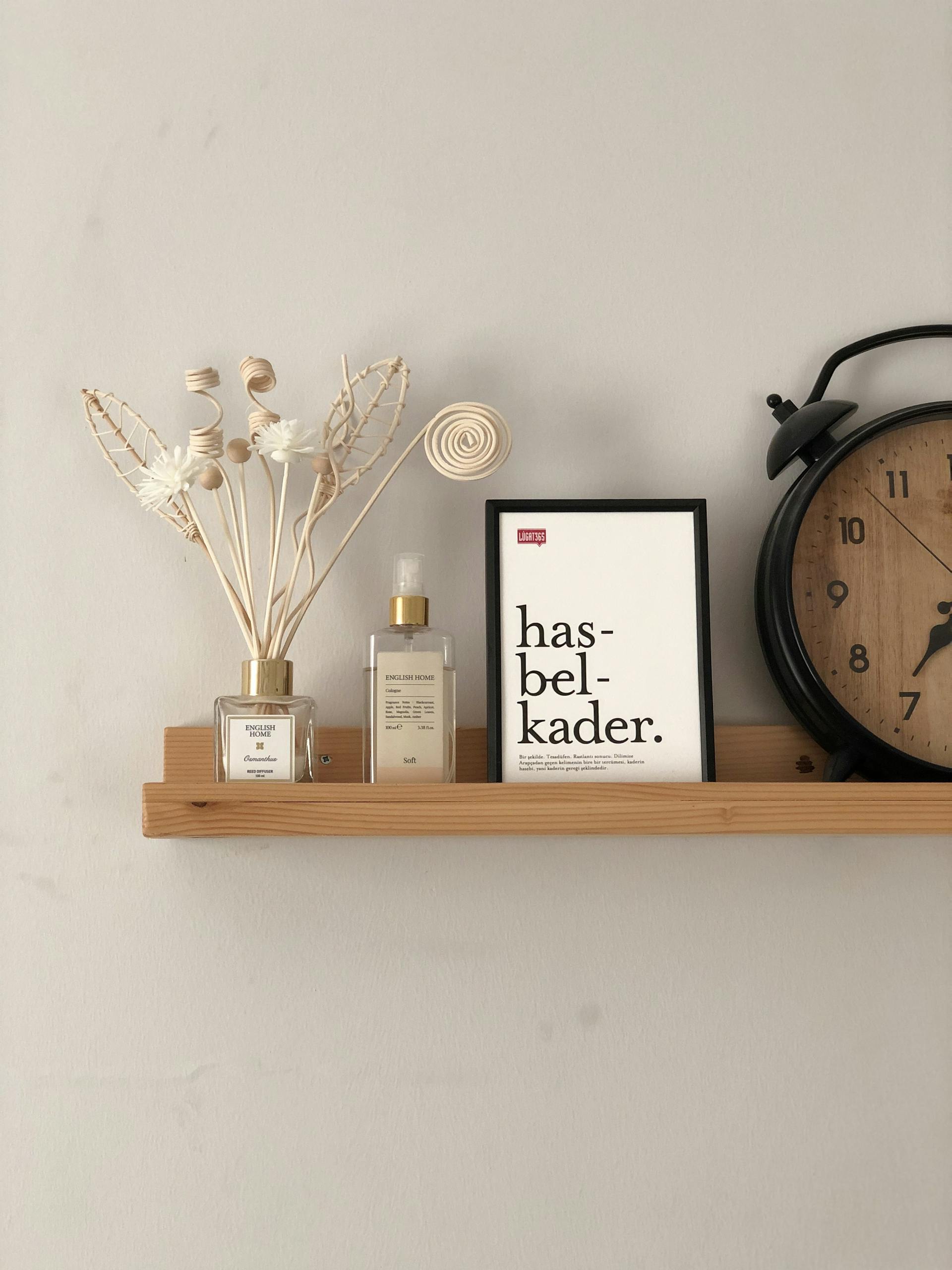 A minimalist wooden shelf featuring decor items, a framed quote, and a vintage clock.