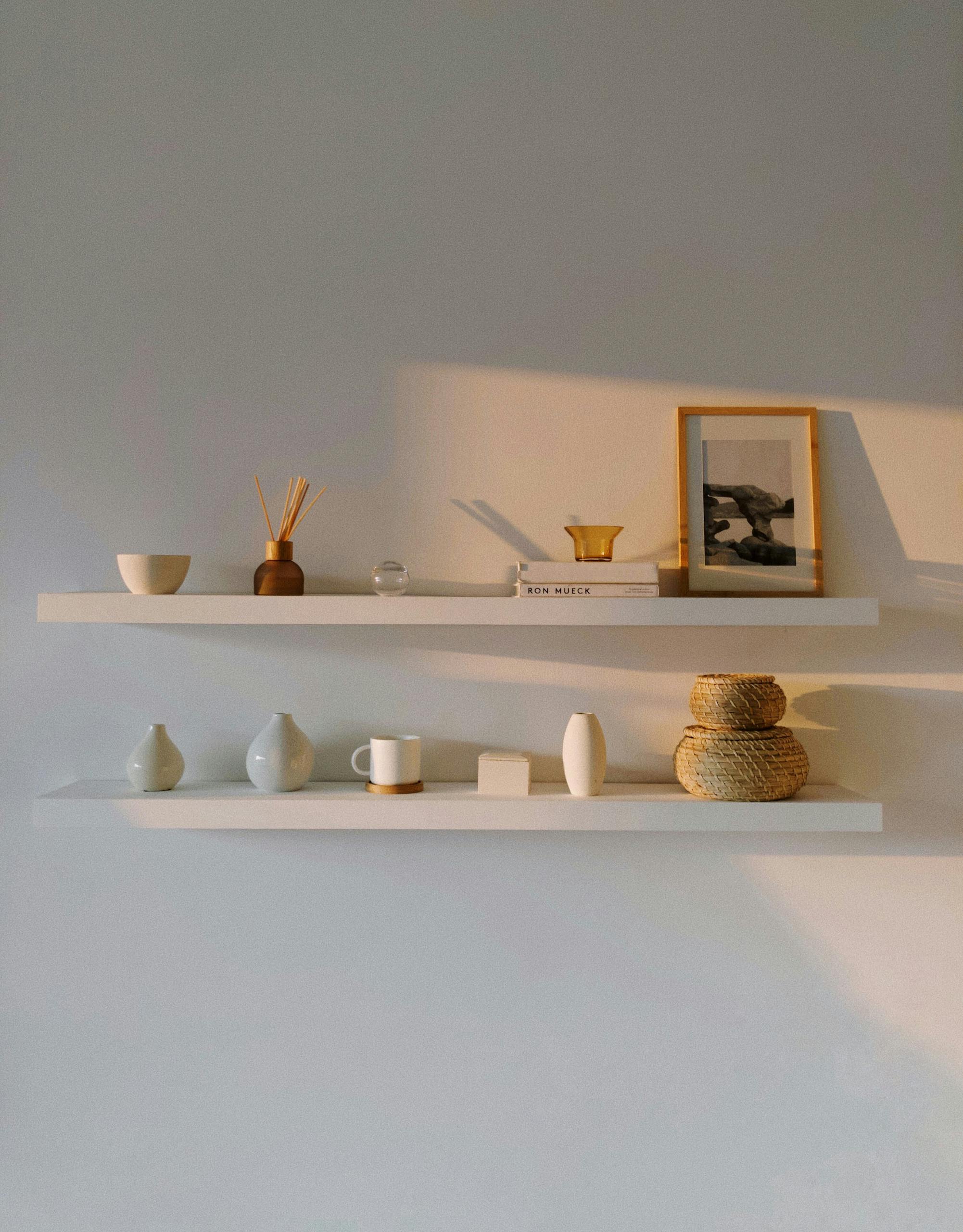 Elegant minimalist shelves with various home decor items illuminated by soft natural light.