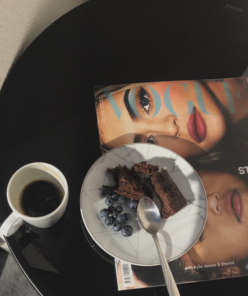 A quiet morning moment with coffee, dessert, and a magazine, representing reflection, slow living, and seasonal planning for moms.